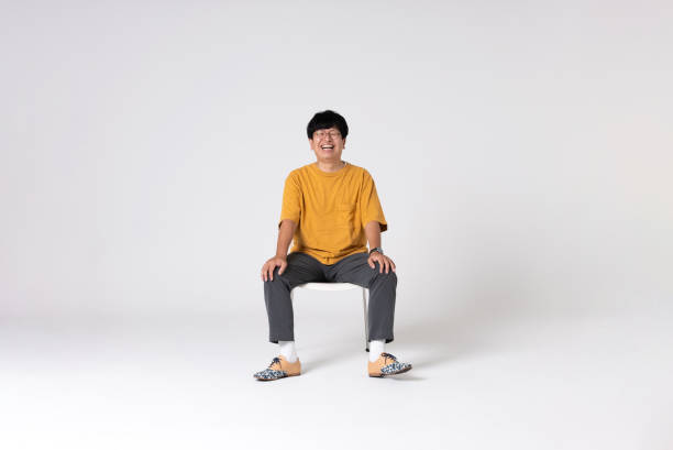 Full-length portrait of an Asian man on a white background. Full-length portrait of an Asian man on a white background.
Full body shot. Japanese male, 30s.
Healthy and confident figure.
sitting on a chair. smiling.
Looking at camera.
Shot in a studio with a white background.
Horizontal shot. sitting stock pictures, royalty-free photos & images