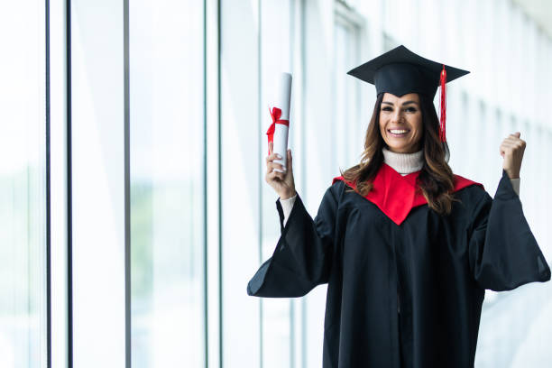 istock Female graduate celebrating victory sign on Uni 1328527953