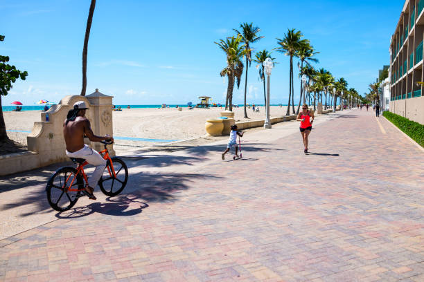 passeio de praia na flórida com pessoas sinceras andando de bicicleta correndo de bicicleta - beach family boardwalk footpath - fotografias e filmes do acervo
