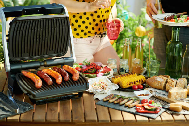 istock desk with electric grill and grilled sausages 1328528253