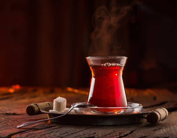 古い木製のテーブルの上に、黒い伝統的なトルコ茶のグラスが立っています。暗い背景の後ろ。 - tea afternoon tea tea party cup ストックフォトと画像