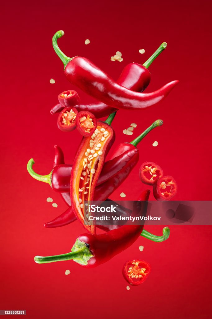 Fresh red chilli peppers and cross sections of chilli pepper with seeds floating in the air. File contains clipping paths. Chili Pepper Stock Photo