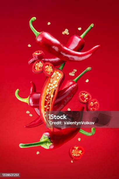 Fresh Red Chilli Peppers And Cross Sections Of Chilli Pepper With Seeds Floating In The Air File Contains Clipping Paths Stock Photo - Download Image Now