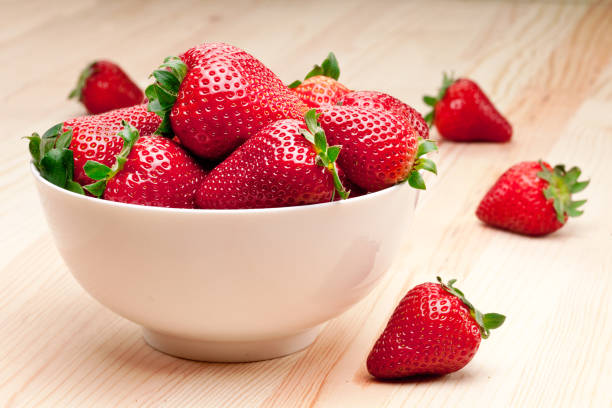 istock Strawberries in the bowl on wooden table. 1328531857