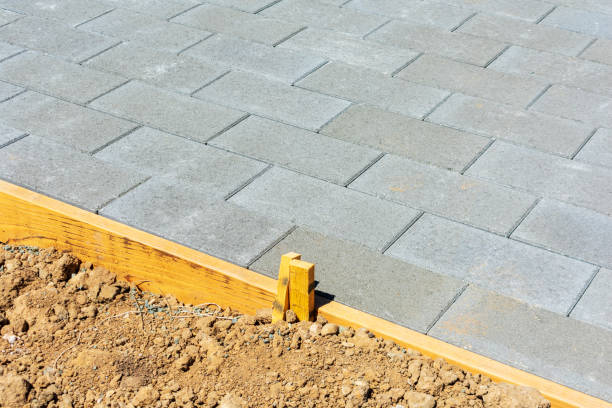 istock Stone pavers installation in progress. Gray Pavers installed in a running bond pattern next to wooden formwork. Close up. 1328533764