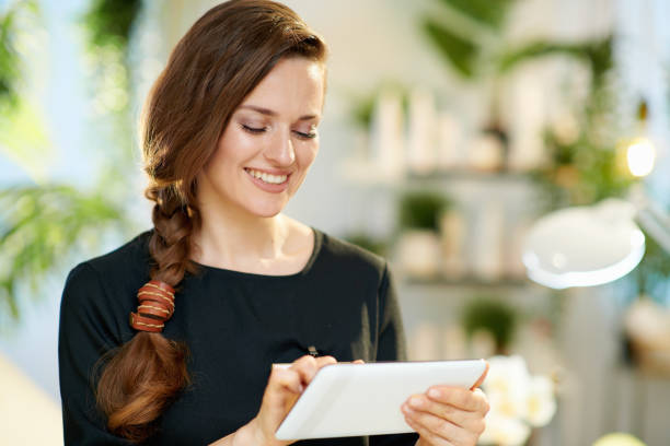 istock happy woman employee in beauty studio using tablet PC 1328534475