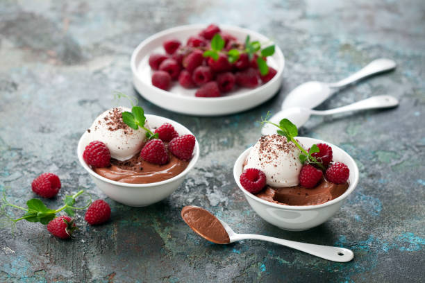 Chocolate mousse dessert with vanilla ice cream and fresh raspberries in white serving bowls