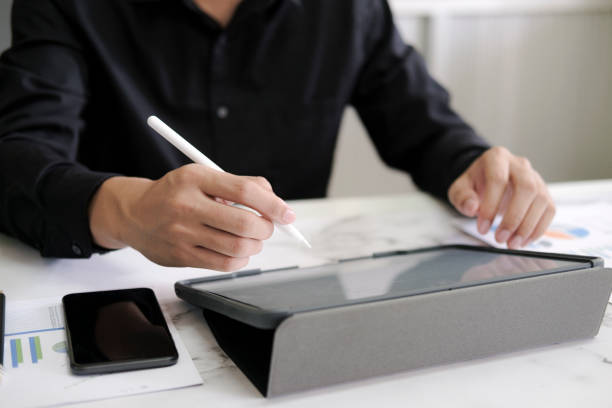 istock Business man with stylus pen writing on digital notepad 1328543179