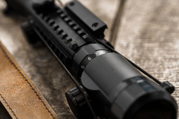 istock The optical sight and shotgun on wooden backgorund 1328545203