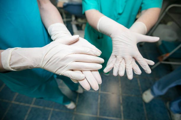 istock Doctors wearing rubber gloves treat their hands before surgery. 1328549129