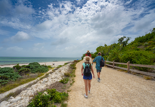 Family walking to the beach with sand dunes. People hiking on Beautiful Florida beach. Bahia Honda State Park, Florida Keys, FLorida,USA.