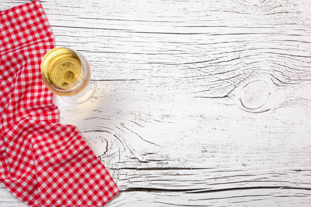istock Wineglass with towel on white cracked wooden table 1328552624
