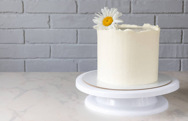 istock tall white cake on a stand with a decor of a chamomile flower 1328556000