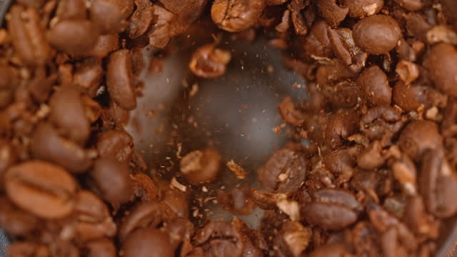 SLO MO LD Roasted coffee beans being ground in a coffee grinder
