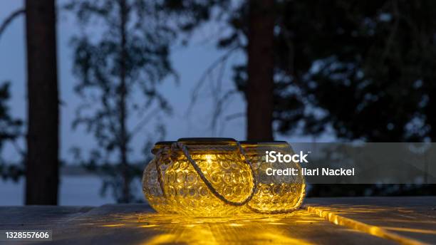 Portable Garden Lights On A Wooden Table Outdoors In Finnish Summer Twilight Stock Photo - Download Image Now