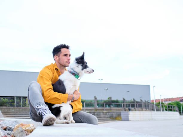 istock young man hugs his border collie dog 1328559028