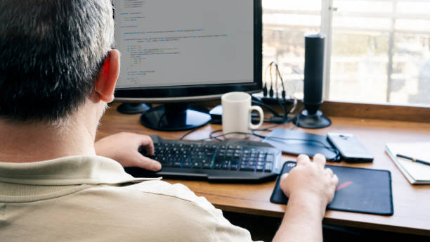 istock Working at home with a desktop computer, man typing. One Male hand on the keyboard and the other on mouse in his own home. work at home, 1328559655