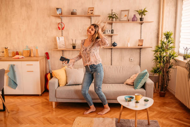 istock Woman singing and dancing at home 1328559744
