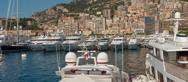 Monaco, Monaco - July 08 2008: Luxury yachts in the Monaco harbor with large apartment complexes in the background.