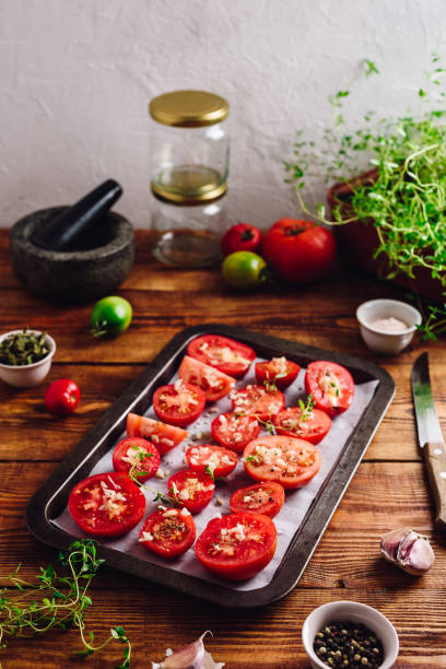 istock Halved Tomatoes with Thyme and Garlic on Baking Sheet 1328561565