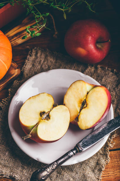 istock Two Halves of Red Apple on White Plate 1328561649