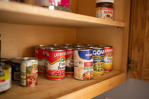 This is a still life photograph of canned food on a kitchen pantry shelf in Chicago, USA.