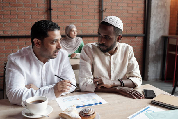 istock Businessmen Discussing Chart in Cafe 1328564655