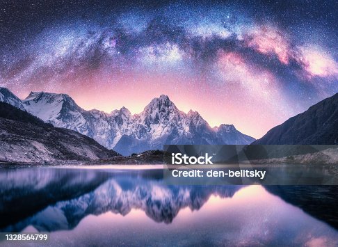 istock Milky Way over snowy mountains and lake at night. Landscape with snow covered high rocks, purple starry sky, reflection in water in Nepal. Sky with stars. Bright milky way in Himalayas. Space. Nature 1328564799