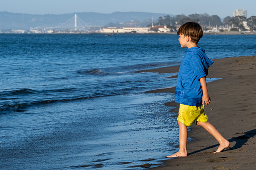 caucasian Little boy walking in the beach