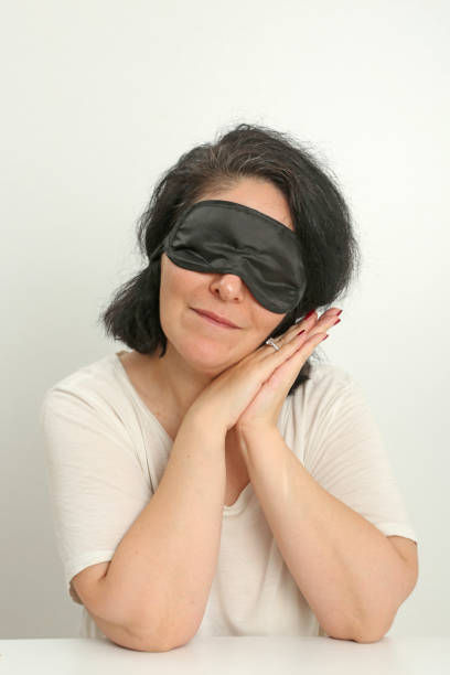 istock cute woman in sleeping mask front of white background. 1328566609