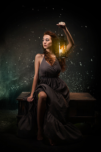 Portrait of woman wearing dress holding a lamp.\nSad and thoughtful artwork with candle light in hand.