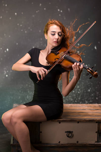 Beautiful girl playing the violin at outdoors.