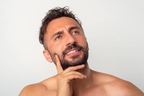 istock Portrait of handsome young shirtless man  thinking while standing against grey background. 1328569028