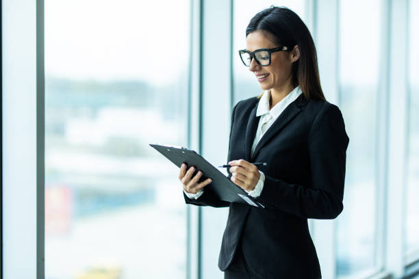 istock Confident businesswoman going to work holding clipboard in modern office 1328569074