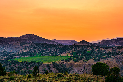 Ranch Land View Flat Tops Mountains Summer Colorado - Rural scenic views with wildfire smoke in air creating hazy skies and warm colors at sunset.