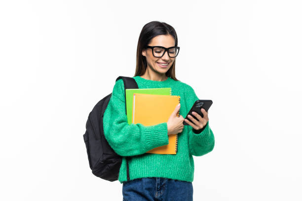 istock Young woman university student with backpack and books sending a sms on cell phone, isolated on white background 1328571276