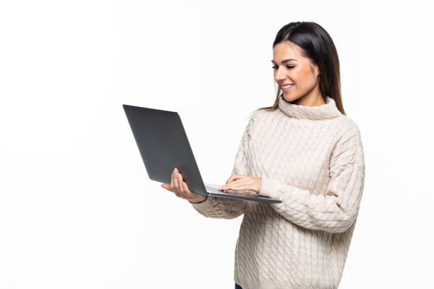 istock Young smiling woman using laptop computer and looking camera isolated over white 1328571637
