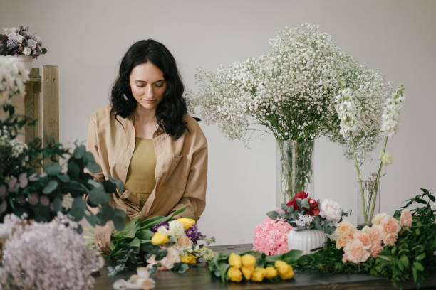 istock Young woman florist working in her flower studio, making beautiful bouquet using fresh plants and flowers. 1328571712