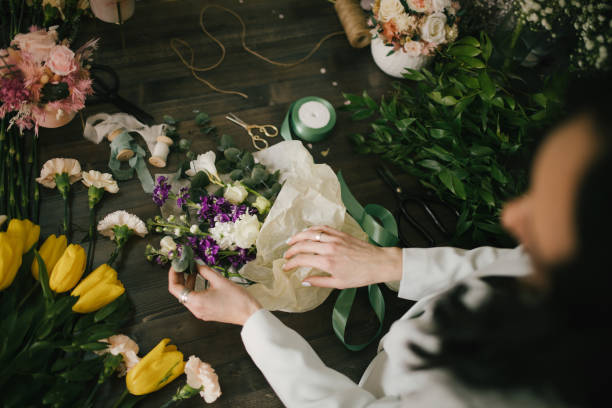 istock Young woman florist working in her flower studio, making beautiful bouquet using fresh plants and flowers. 1328571717