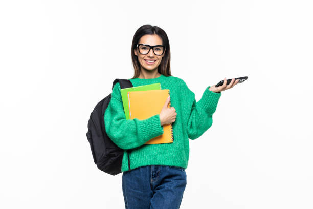 istock Young woman university student with backpack and books sending a sms on cell phone, isolated on white background 1328573123