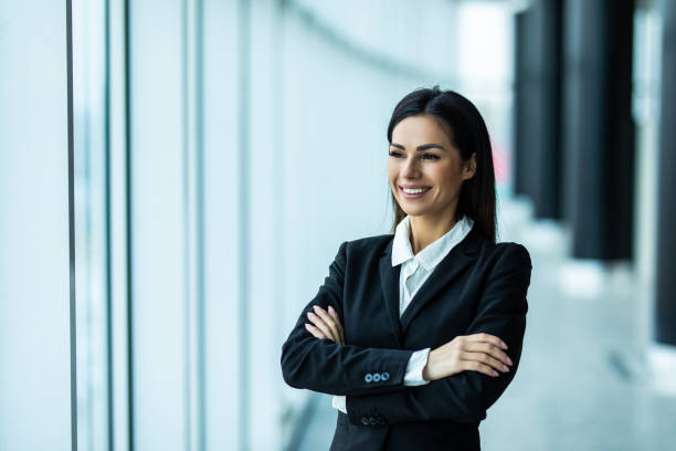 istock Young businesswoman standing with arms folded at office 1328573191