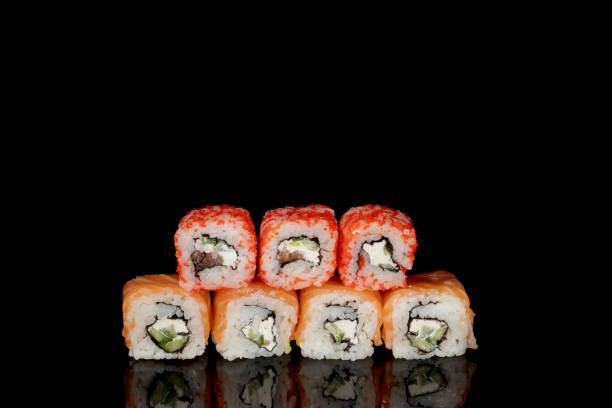 istock Philadelphia roll with salmon, cheese and cucumber on a black background with reflection. Sushi Philadelphia 1328573906