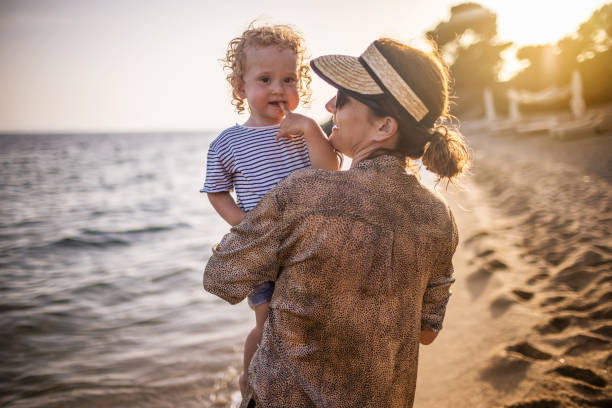 istock Baby boy with mother at the beach 1328575066