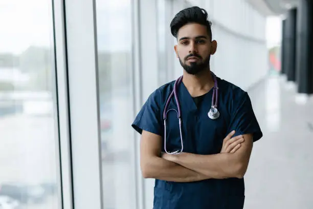 Young Indian doctor with a stethoscope on among a modern hospital, Indian medicine, health and self-care.