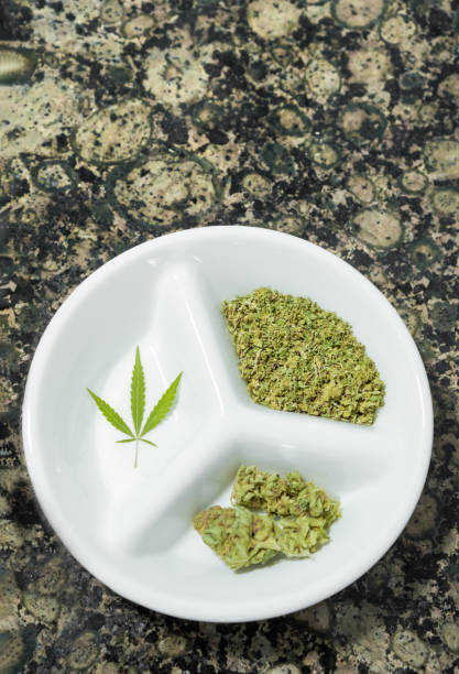 istock Top view of tray with crushed cannabis, marijuana buds and leaf on a marble table, copy space top. 1328580208
