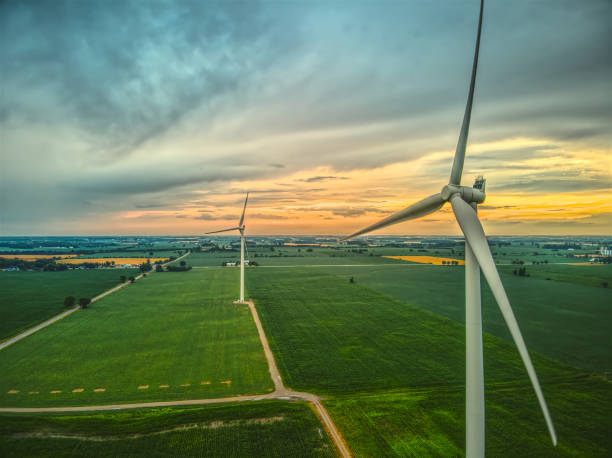 Wind Turbines at Sunset, Southwestern Ontario, Canada An aerial image of two wind turbines in rural farmland at sunset in Southwestern Ontario, Canada climate crisis photos stock pictures, royalty-free photos & images