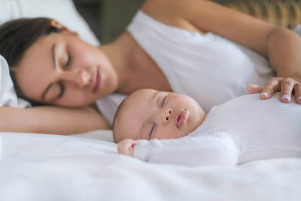母と新生児の赤ちゃんは並んで眠っている - 睡眠 ストックフォトと画像