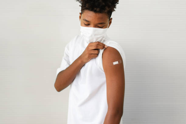 istock African-American boy showing adhesive bandage on shoulder after getting vaccinated during coronavirus or covid-19 pandemic at hospital,Vaccination concept 1328596459