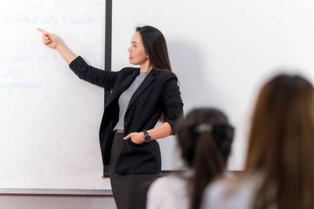 istock A middle-aged Asian woman teacher helping a student during on a class in the classroom university 1328598865