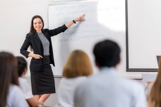 istock A middle-aged Asian woman teacher helping a student during on a class in the classroom university 1328599579